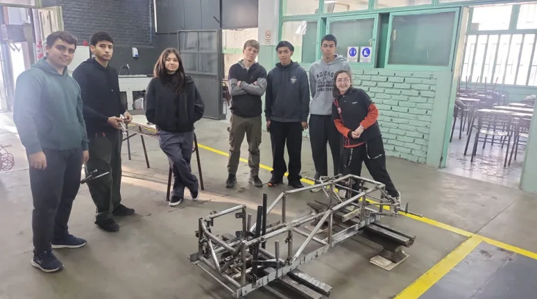 Equipo de estudiantes de la Escuela Boero colaborando en el ensamblaje de su vehículo eléctrico para el Desafío YPF ECO.
