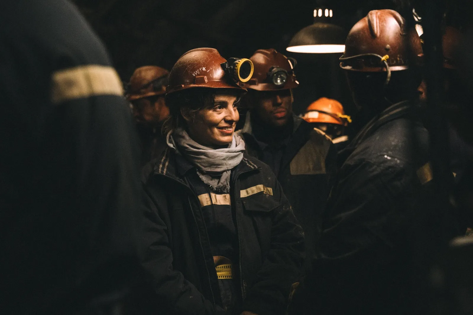 Lux Pascal caracterizada como Carlita, con ropa de minera, trabajando o posando en el entorno de una mina de carbón en la Patagonia.