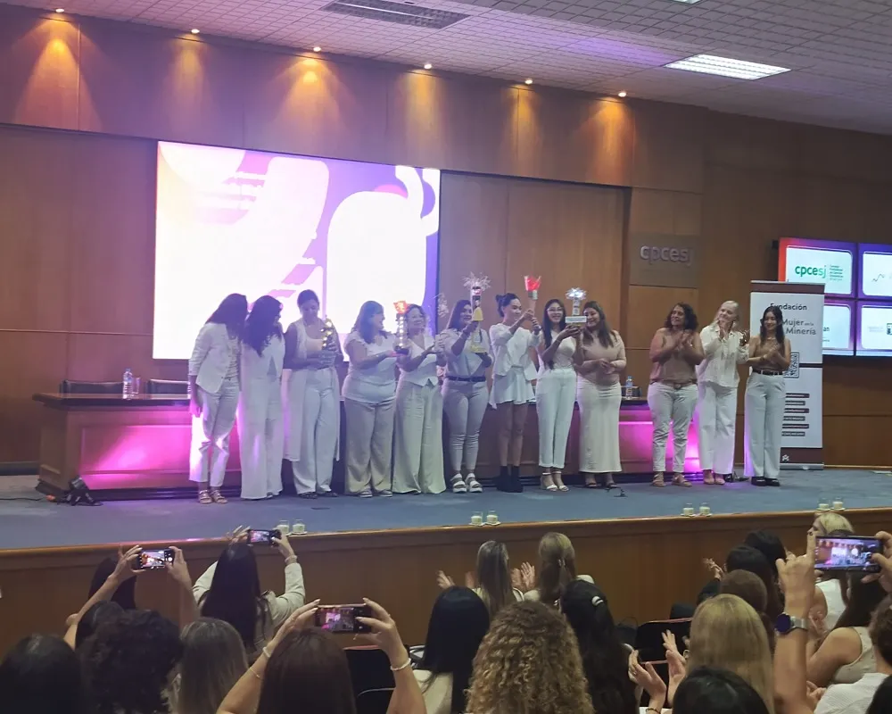 Fotografía del escenadio del del Consejo Profesional de Ciencias Económicas durante el evento Mision de Mujeres de la Fundación Mujeres en la minería. En el escenario un grupo de mujeres con antorchas